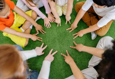 leerlingen vormen kring met hun handen op de grond