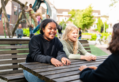 Leerlingen kletsen met elkaar op schoolplein