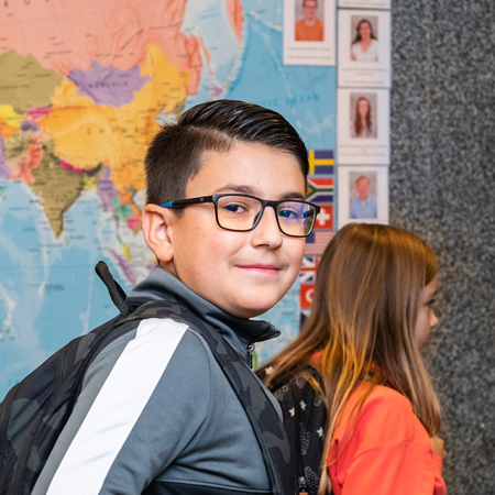 leerlingen basisschool lopen langs wereldkaart