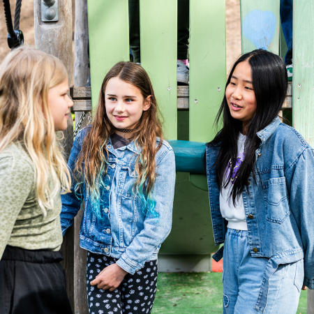 Basisschoolleerlingen kletsen met elkaar op het schoolplein